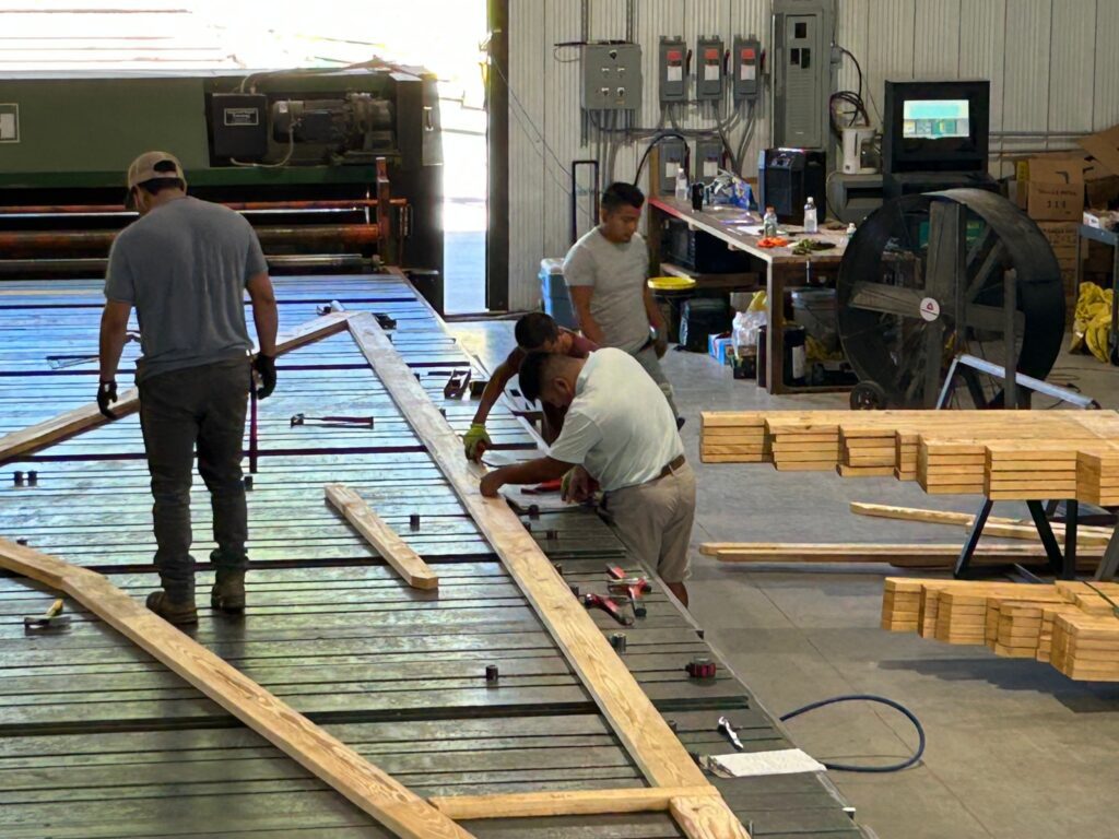 Workers building a custom truss in our warehouse